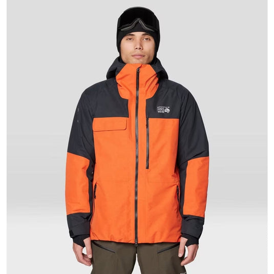 Person wearing an orange and black jacket with a visible brand logo on a gray background