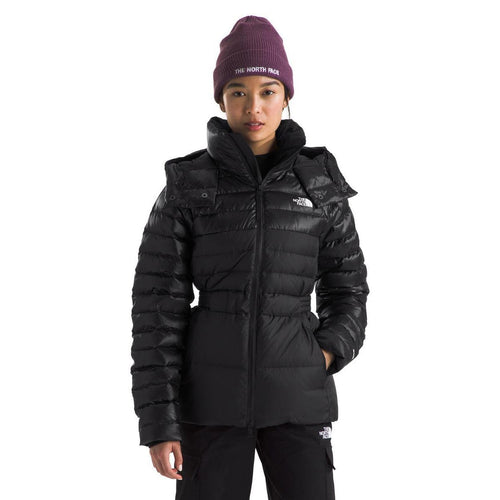 Person wearing a black jacket and purple beanie with 'The North Face' logo on a white background
