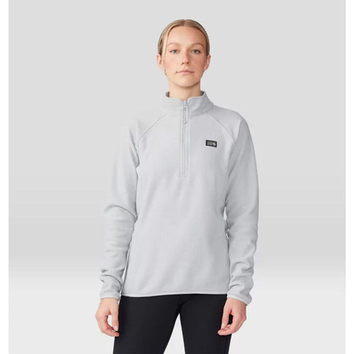 Person wearing a light gray pullover with a brand logo on a white background