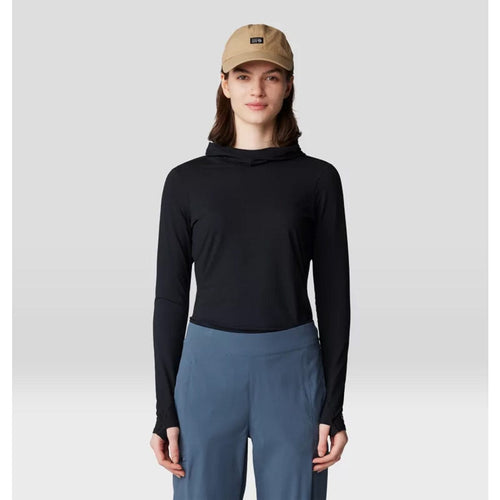Person wearing a black long-sleeve top and blue pants with a beige cap on a light gray background