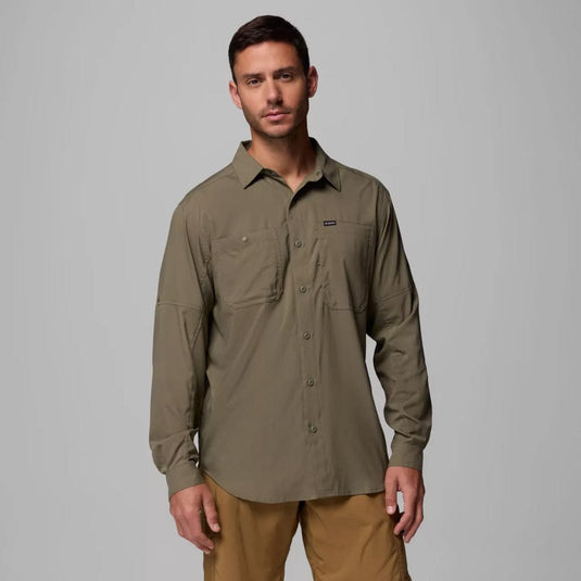 Man wearing a green shirt with a logo on a gray background