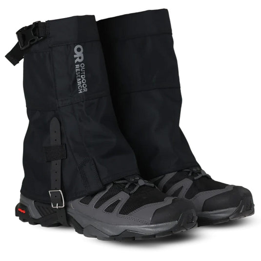 Black hiking gaiters with gray shoes on a white background