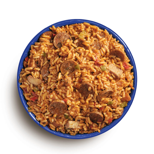 Bowl of jambalaya with sausage and vegetables on a white background