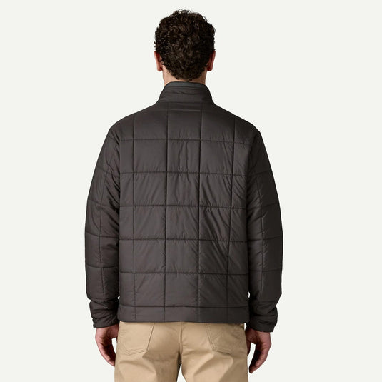 Man wearing a dark gray quilted jacket on a white background