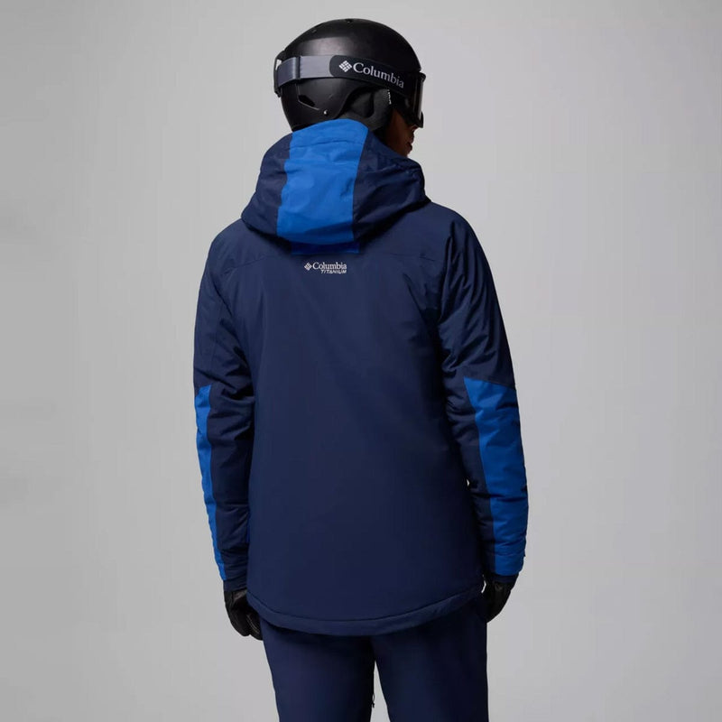 Load image into Gallery viewer, Person wearing a blue and navy Columbia jacket with a helmet on a gray background
