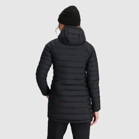 Person wearing a black puffer jacket on a light gray background