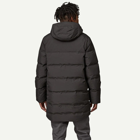 Person wearing a black puffer coat on a white background