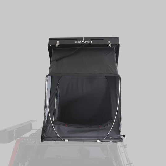 Black rooftop tent with 'ikamper' branding on a gray background