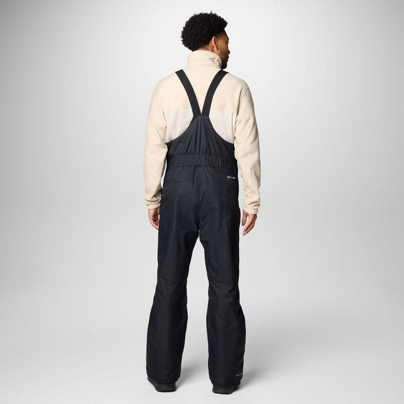 Load image into Gallery viewer, Person wearing a beige jacket and black bib overalls on a white background
