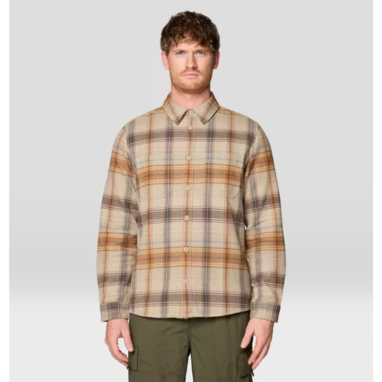 Man wearing a plaid shirt and green pants on a light gray background