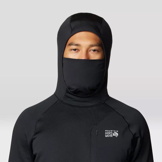Person wearing a black hooded jacket with a visible brand logo on a light gray background