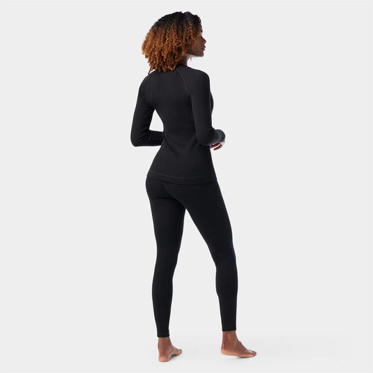 Person wearing a black long-sleeve top and leggings on a white background