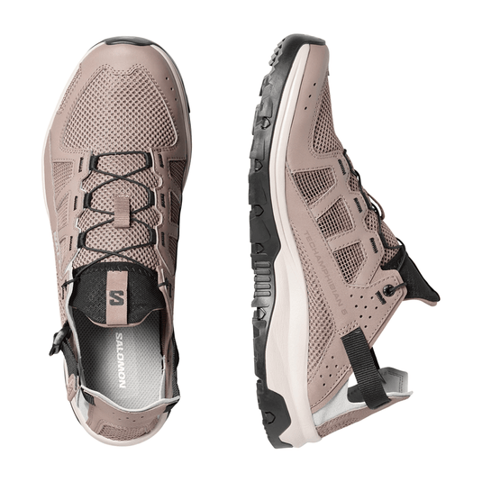 Pair of beige hiking shoes with black accents on a white background