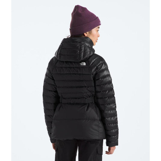 Person wearing a black puffer jacket and purple beanie on a white background