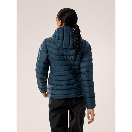 Person wearing a blue puffer jacket on a plain background