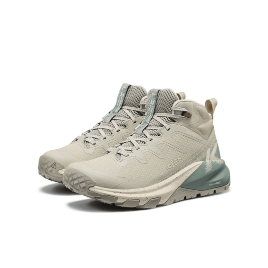 Pair of beige hiking boots with blue accents on a white background