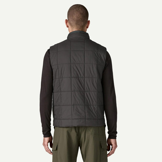 Man wearing a dark gray quilted vest on a white background