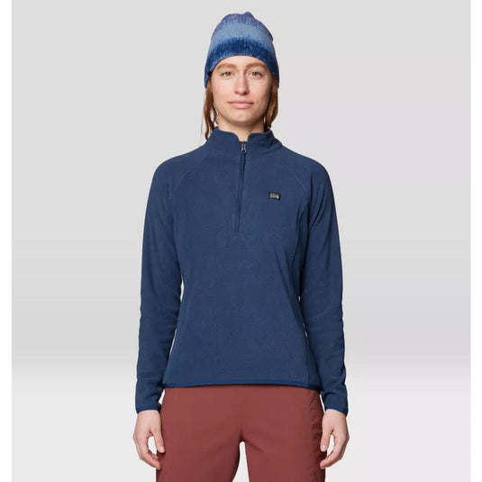 Person wearing a blue pullover, beanie, and maroon pants on a light gray background