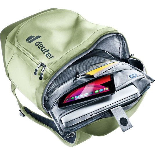 Green backpack with a laptop and tablet inside, featuring the Deuter brand.