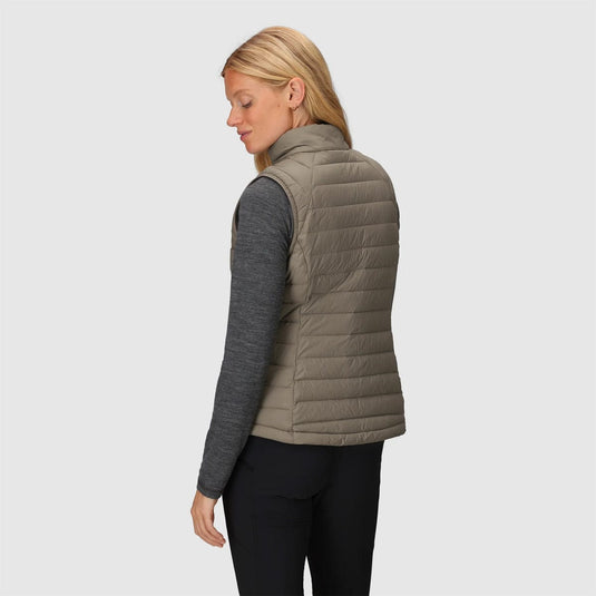 Woman wearing a beige puffer vest on a light gray background