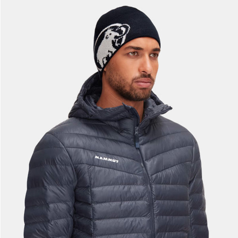 Load image into Gallery viewer, Man wearing a dark gray puffer jacket with &#39;Mammut&#39; branding and a black beanie with a bear design.
