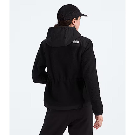 Person wearing a black hoodie with a logo on the back against a white background