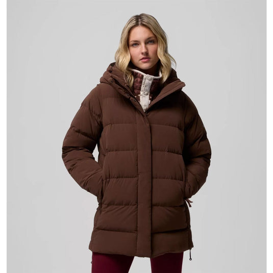 Woman wearing a brown puffer coat on a gray background