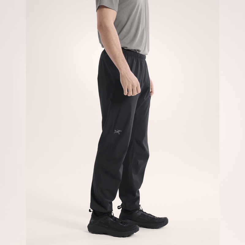 Load image into Gallery viewer, Person wearing black pants with a brand logo on a light background
