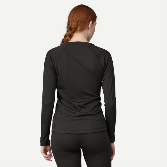 Person wearing a black long-sleeve athletic top on a white background