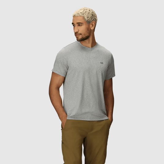 Man wearing a gray t-shirt and brown pants on a light gray background