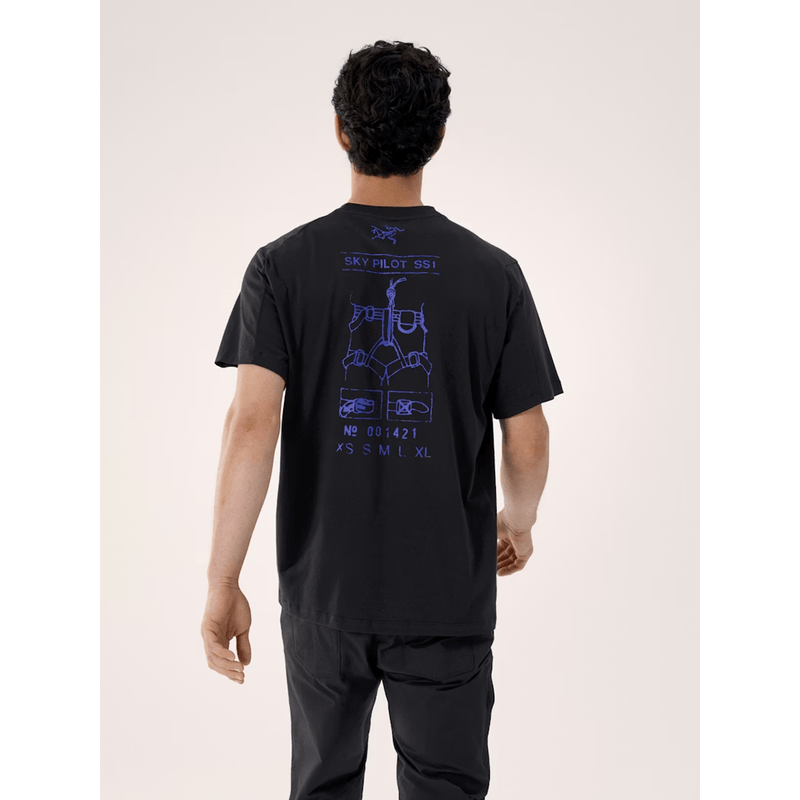 Load image into Gallery viewer, Person wearing a black t-shirt with blue graphics on the back, standing against a light gray background

