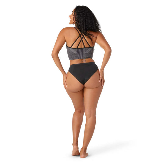Woman wearing a gray bikini top and black bottoms on a white background