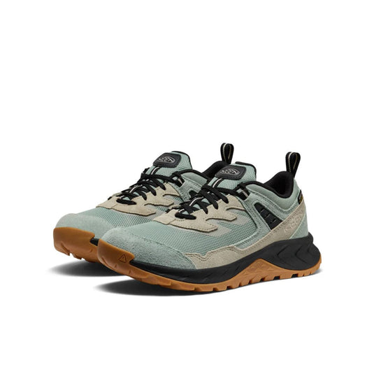 Pair of green and black sneakers with brown soles on a white background