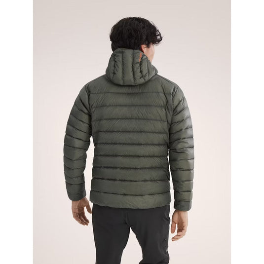Person wearing a green puffer jacket on a plain background