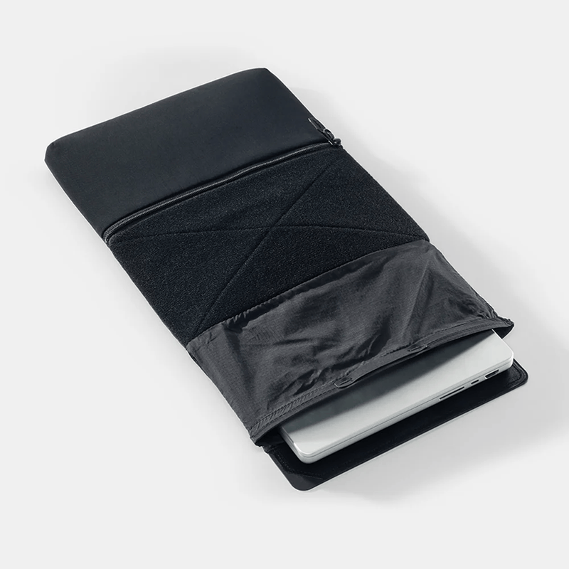 Load image into Gallery viewer, Black laptop sleeve with a white laptop inside on a light gray background
