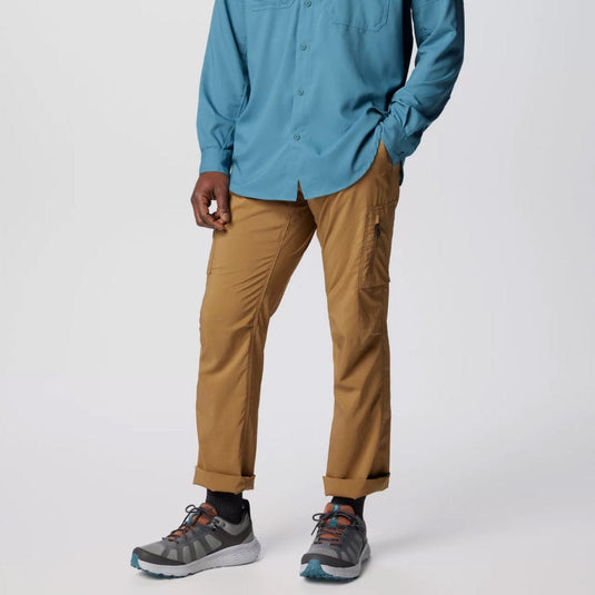 Person wearing a blue shirt, brown pants, and gray shoes on a white background