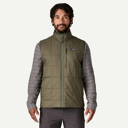 Man wearing a green puffer vest with a visible brand logo on a white background