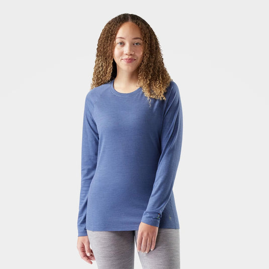 Woman wearing a blue long-sleeve shirt on a white background