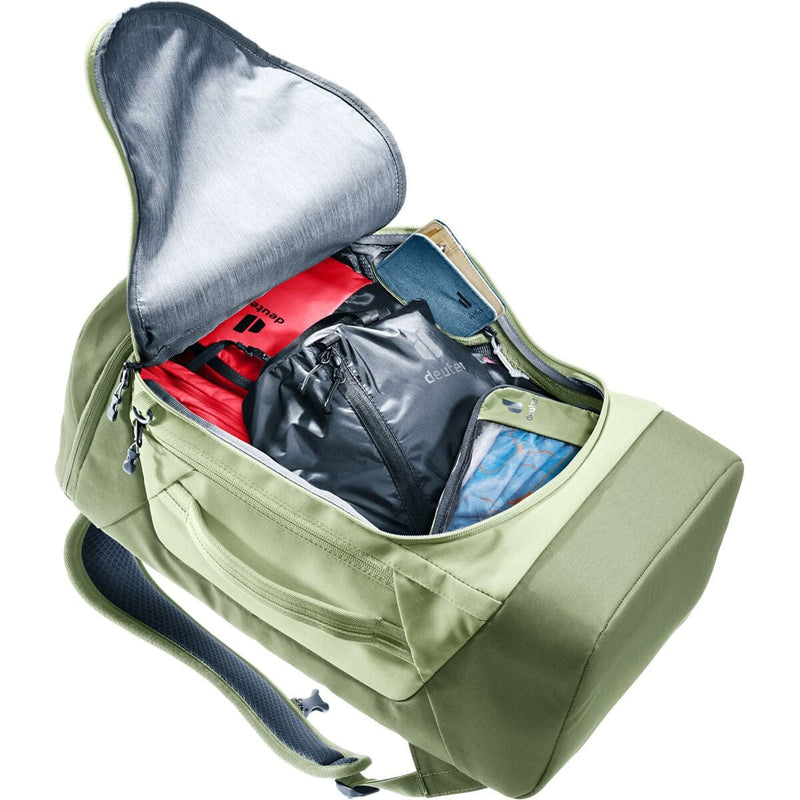 Load image into Gallery viewer, Green backpack with open compartment showing organized items on a white background
