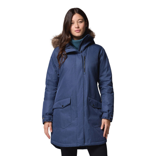 Woman wearing a blue winter coat with fur hood on a white background