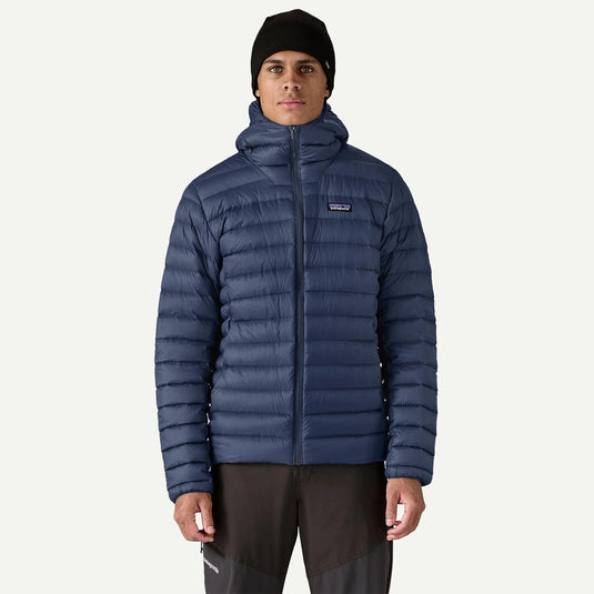 Person wearing a blue puffer jacket with a brand logo on a white background