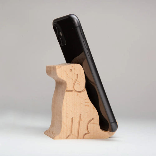 Wooden phone stand holding a black smartphone on a light gray background