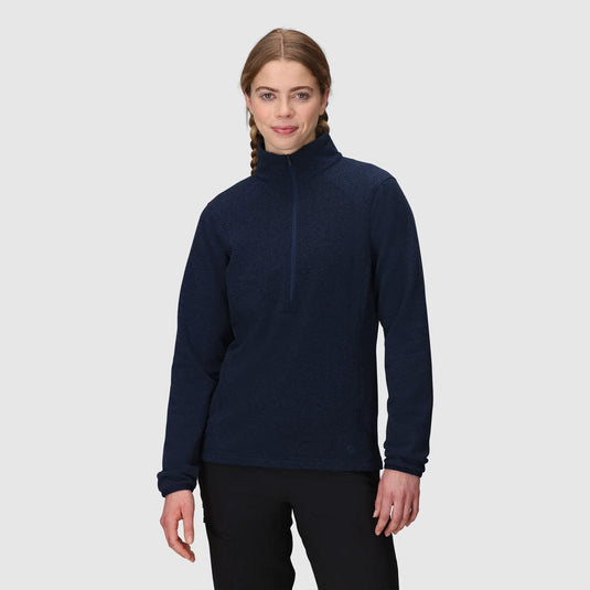 Woman wearing a navy blue turtleneck sweater on a light gray background