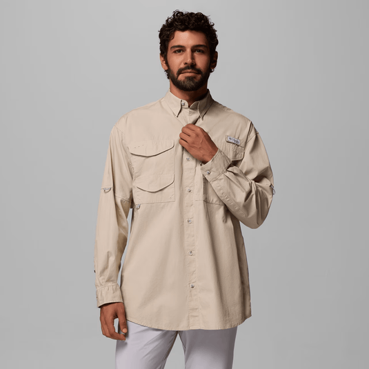 Man wearing a beige long-sleeve shirt with pockets on a gray background