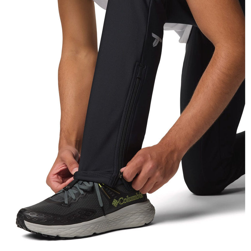 Load image into Gallery viewer, Person wearing black Columbia running shoes with pants pulled up to the knee on a white background
