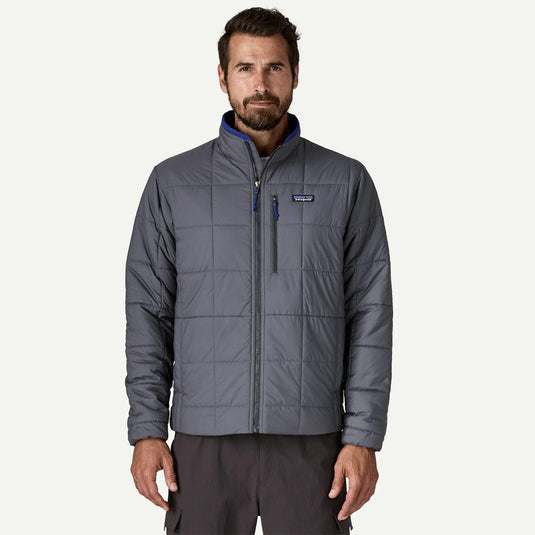 Man wearing a gray quilted jacket on a white background