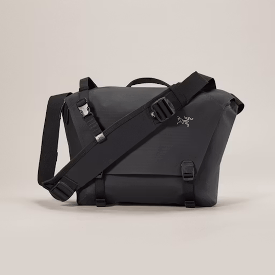 Black shoulder bag with a visible brand logo on a beige background