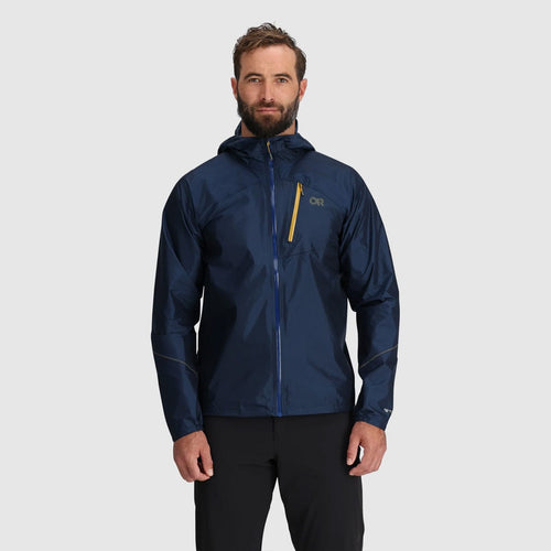 Man wearing a navy blue jacket with a brand logo on a light gray background