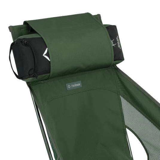 Green camping chair with a headrest, featuring Helinox logo, on a light gray background