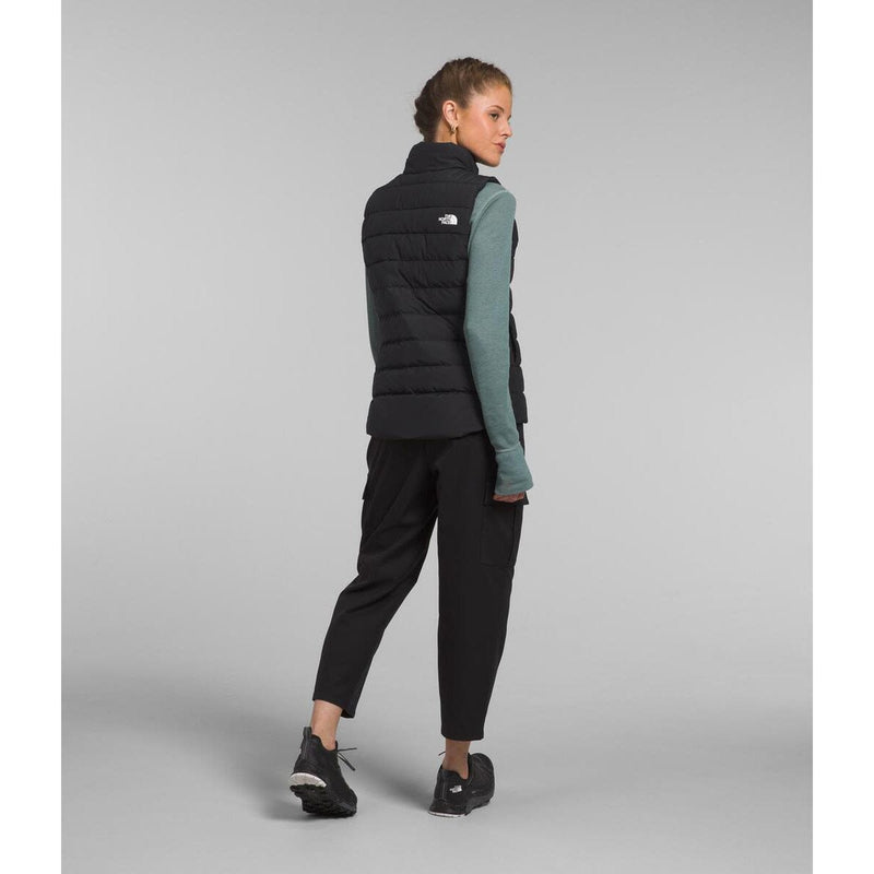 Load image into Gallery viewer, Woman wearing a black puffer vest with a gray background
